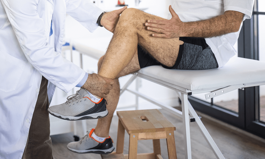 An orthopedic doctor working on a patient's leg and knee.
