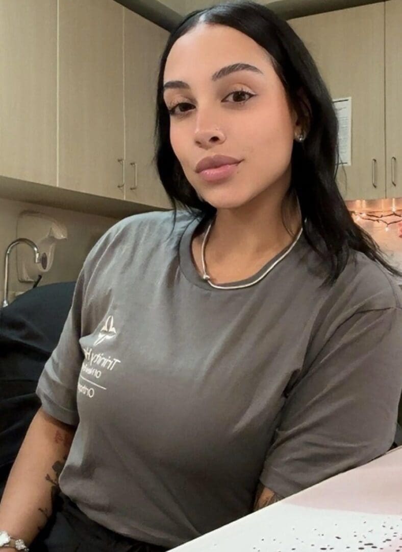 Young woman posing indoors with a confident expression.